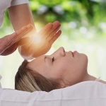 A Reiki practitioner sends energy to a client's head